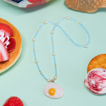 Oeuf au plat - collier élastique, pendentif en céramique