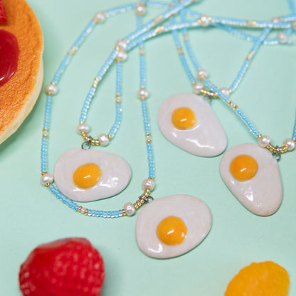 Oeuf au plat - collier élastique, pendentif en céramique